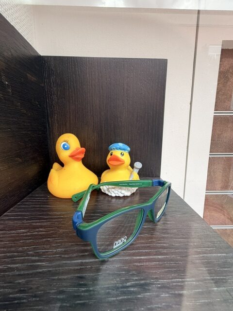 Nano Sportbrille für Kinder in Grün-Blau mit Gummienten-Deko im Schaufenster
